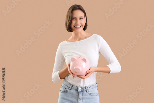 Young woman with piggy bank...