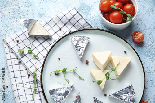 Obraz na plátně Plate with triangles of tasty processed cheese, tomatoes, micro green and napkin