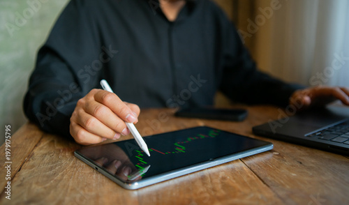 Business professionals are analyzing stock market charts on their laptops, typing in data, planning investments, reviewing reports, forecasting trends, and achieving financial success in a corporate 