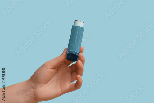 Foto Female hand with modern asthma inhaler on blue background