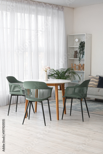 Fotografie Interior of comfortable living room with table, chairs, houseplants, sofa and sh
