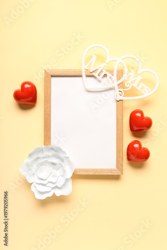 Composition with blank frame and hearts for Valentine's Day on beige background