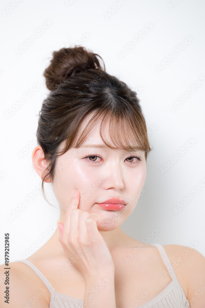 Fototapeta premium 透明感のあるツヤ肌でもニキビや吹き出物に困って悩む表情の美容やスキンケアイメージのクローズアップ