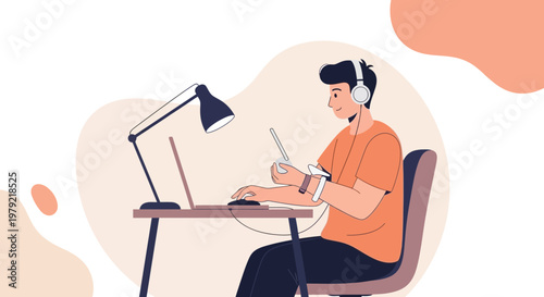 Young man with headphones working on laptop at desk with lamp, holding stylus