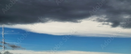 Layered clouds creating contrast between dark stormy sky and bright blue atmosphere