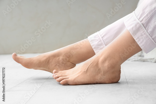 Barefoot woman on floor wit...