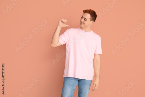 Young man pointing at his t...
