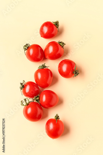 Many fresh cherry tomatoes on orange background