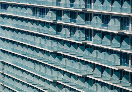 Foto This image showcases a striking modern building with unique glass balconies, emphasizing its architectural elegance and contemporary style in urban settings