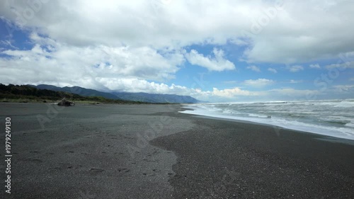 Wide Dark Sand Beach With Mountain Coast