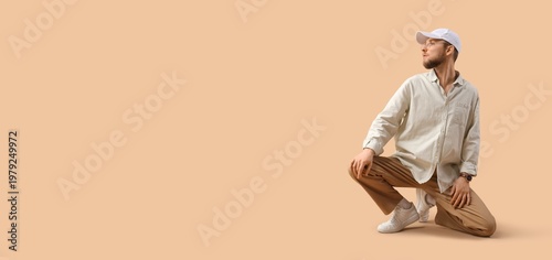 Stylish young man on beige ...