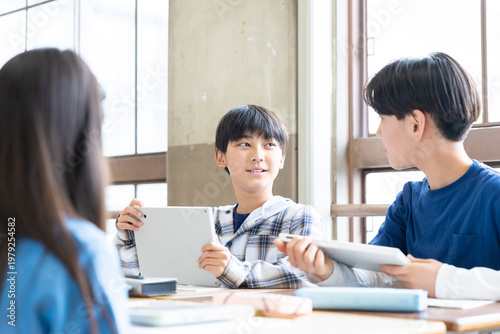 タブレットを使ってグループワークをする小学生