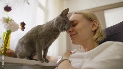 Woman Cuddling Gray Cat at Home