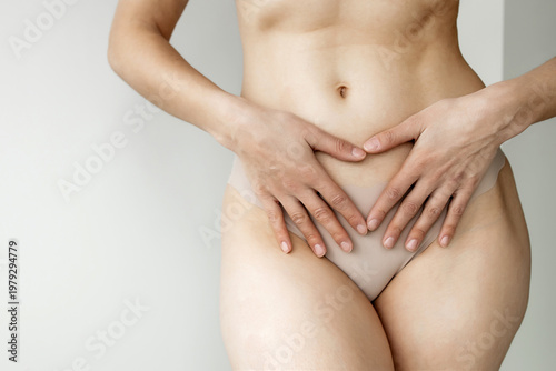 Slim Woman Touching Flat Stomach with Both Hands on Light Background, Female Abdominal Health and Digestive Wellness Concept, Gynecological Care, Body Positivity and Slimming Result