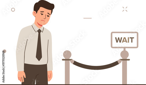 A man waits patiently in line behind a rope barrier indoors.