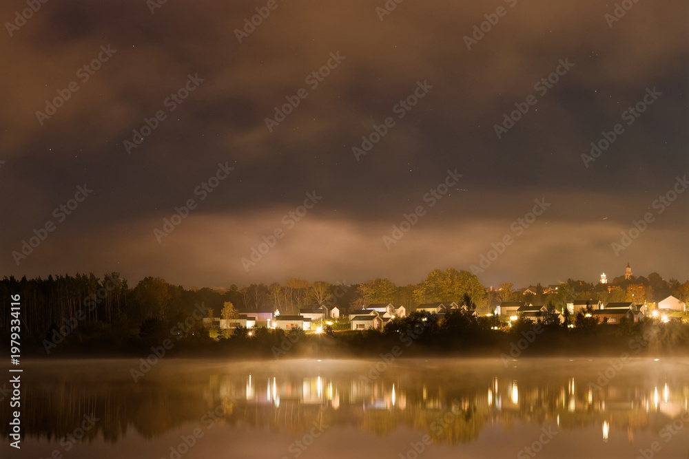 Fototapeta premium Misty Lakeside Village at Night
