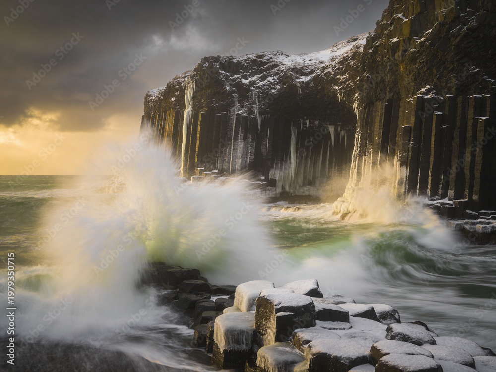 Obraz premium Atmospheric Basalt Formations Under Dramatic Skies and Ocean Spray