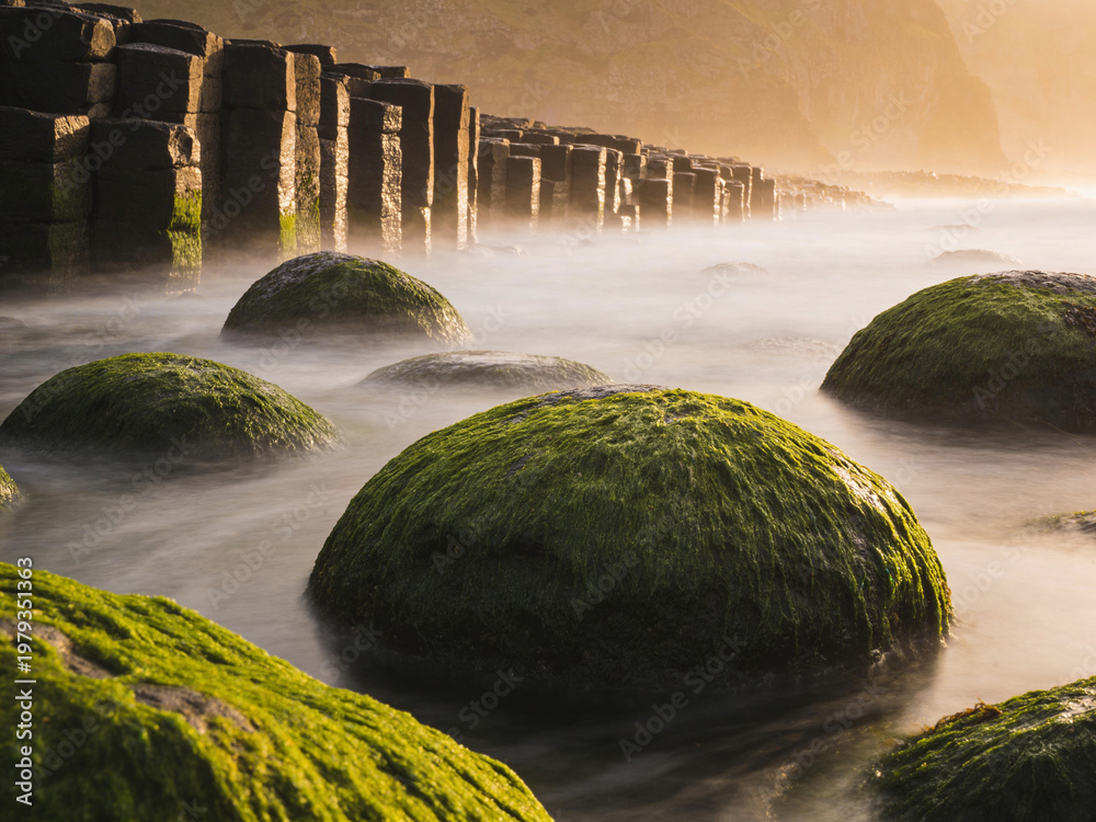Obraz premium Atmospheric Basalt Formations Under Dramatic Skies and Ocean Spray