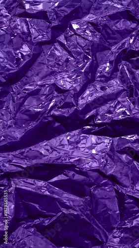 Violet Crumpled Metallic Foil Background Loop, 4K. Fast Changing Wrinkled Foil Texture. Looped Vertical Background Made of Creased Metallic Foil Sheet. Surface of Purple Crumpled Shiny Foil.	