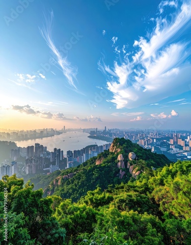 A breathtaking panoramic view showcases a sprawling cityscape nestled amidst lush greenery, bathed in the warm glow of a sunrise under a vibrant blue sky with scattered clouds.