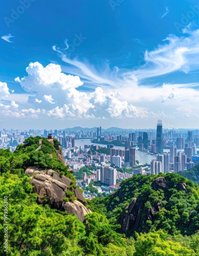 A breathtaking panoramic view showcases a sprawling cityscape nestled amidst lush green hills and a vibrant blue sky dotted with fluffy white clouds.