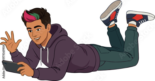 A young man lies on his stomach smiling and using a tablet computer indoors.