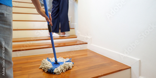 Cleaner mopping wooden staircase at home customer
