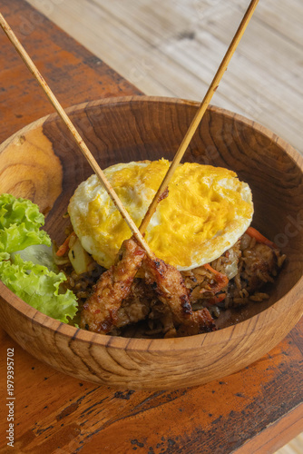 Authentic Indonesian Nasi Goreng fried rice with chicken satay and fried egg