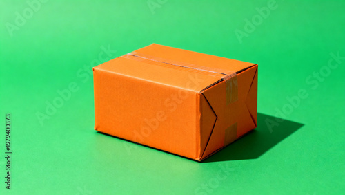 Orange delivery parcel isolated on green chroma key background with clean studio lighting, front three quarter product view, shipping and logistics business concept, detailed stock reference
