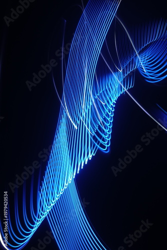 Electric blue light trails against a deep black background
