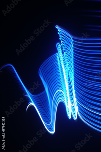 Electric blue light trails against a deep black background