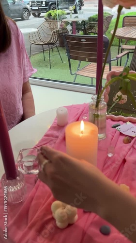 female tarot reader lights a candle with a match before a session at the table
