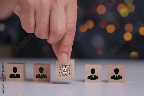 Obraz na płótnie Focused hand placing an ai driven block beside wooden human symbol representing