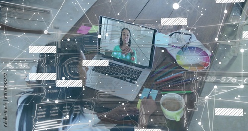 Multitasking seated woman in light top writing at home desk with phone, laptop call, color wheel