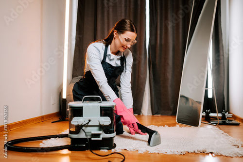 Konstfotografi Cleaner performs wet cleaning on a carpet using a wet vacuum cleaner in a room w