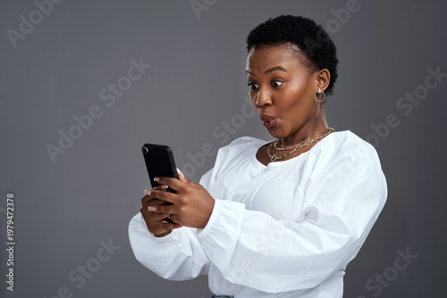 Quadro su tela Phone, surprise and black woman in studio with notification, unexpected news or wow for online alert
