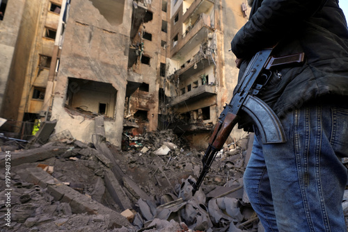 Armed man in destroyed city with damaged buildings