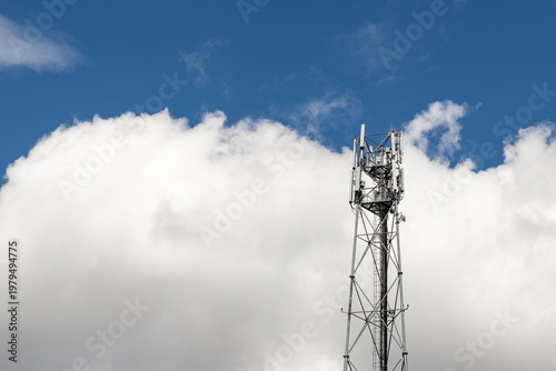 Bottom perspective pov of modern metal steel mobile 5g network wireless telecom tower against clear blue sky background on bright day. Microwave signal broadband equipment base line station mast