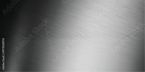 Close up view of brushed metal surface with diagonal light reflection and dark shadows on the left side showing fine linear texture and metallic grain