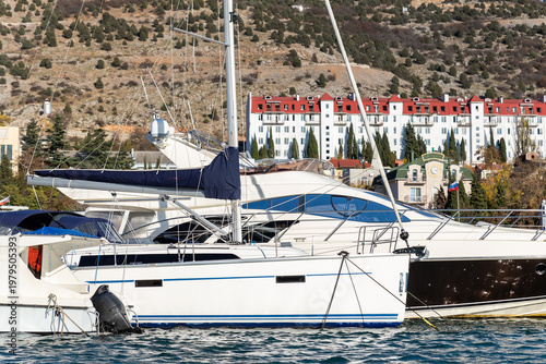 Scenic view of many luxury sailing fishing boat and charter rental speedboats moored at mountain harbor lake bay against mountain landscape backgound on sunny day. Sea marina vessel pier sorage dock