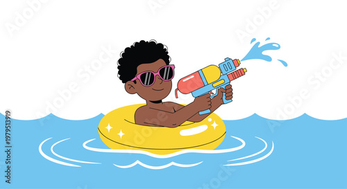 Little boy wearing sunglasses and floating on an inner tube while playing with a colorful water gun in the blue ocean waves.