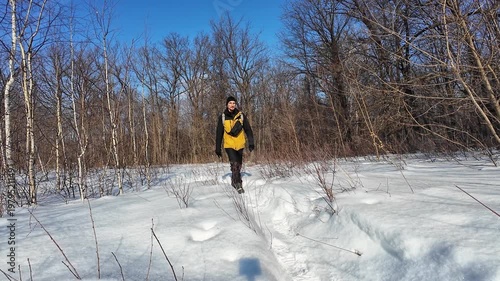 Boots Leave Impressions. Heavy Boots Carve Fresh Impressions Into Snowy Woodland Route. Closeup Of Rugged Boots Making Deep Footprints On Winter Forest Trail With Yellow Jacket Hem Visible