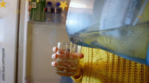 On fridge opening, redhaired woman tilting blue pitcher, pouring and sipping to quench thirst