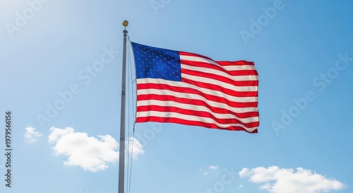 Wallpaper Mural American flag waving in blue sky on flagpole, symbol of freedom and patriotism. Torontodigital.ca