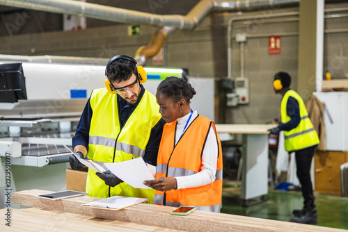 Lumberyard workers reviewing production documents together