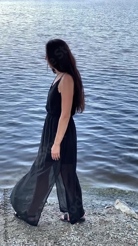 Woman in a black dress. Pond. Waves. Ripples. Slow motion video. High quality 4k footage
