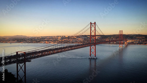 25 de Abril suspension bridge over the water of Tagus river at golden hour, Almada, Lisbon, Portugal, December 2017