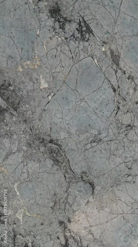 Gray Raw Marble Background Loop, 4K - Fast Changing Stone With Veins Texture. Looped video featuring close‑up shots of a gray stone surface with natural marble‑like veining and texture variation.