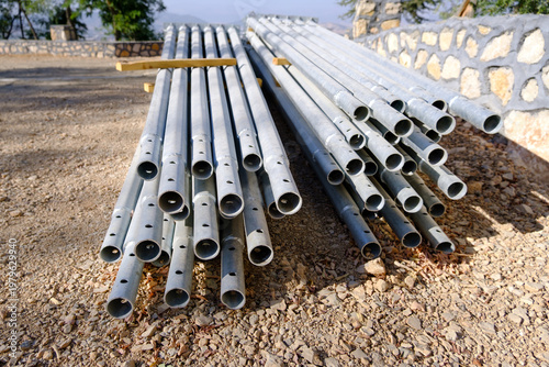 Metal lampposts stacked at construction site before installation