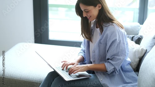 Happy Young Woman Working on Laptop and Taking a Phone Call at Home